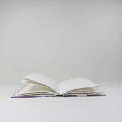Handmade book standing upright, showing paste paper cover and blank text block