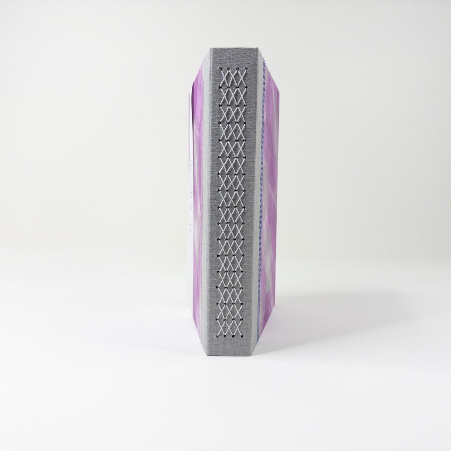 Grey linen spine crossed with a pale lattice of linen thread stitching