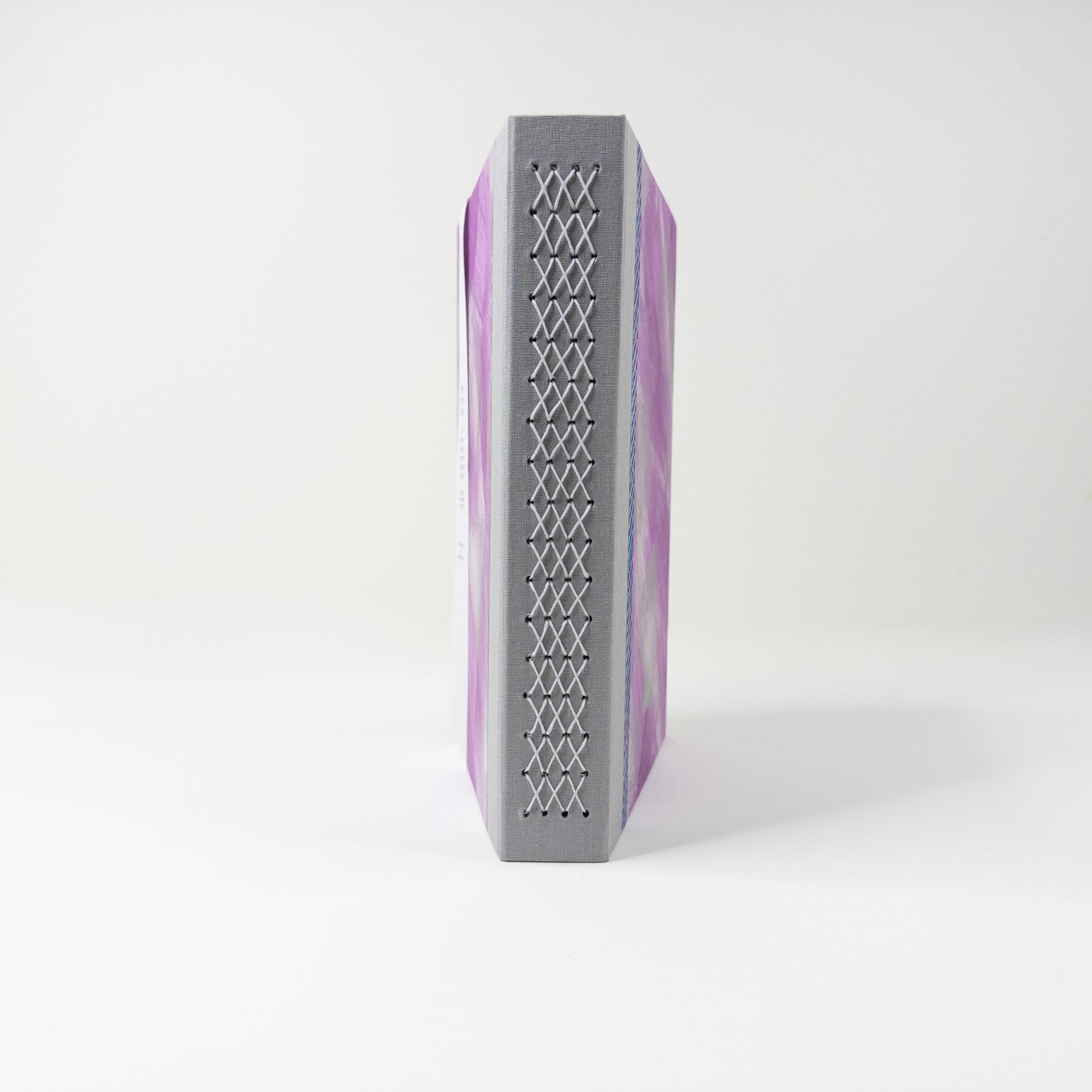 Grey linen spine crossed with a pale lattice of linen thread stitching