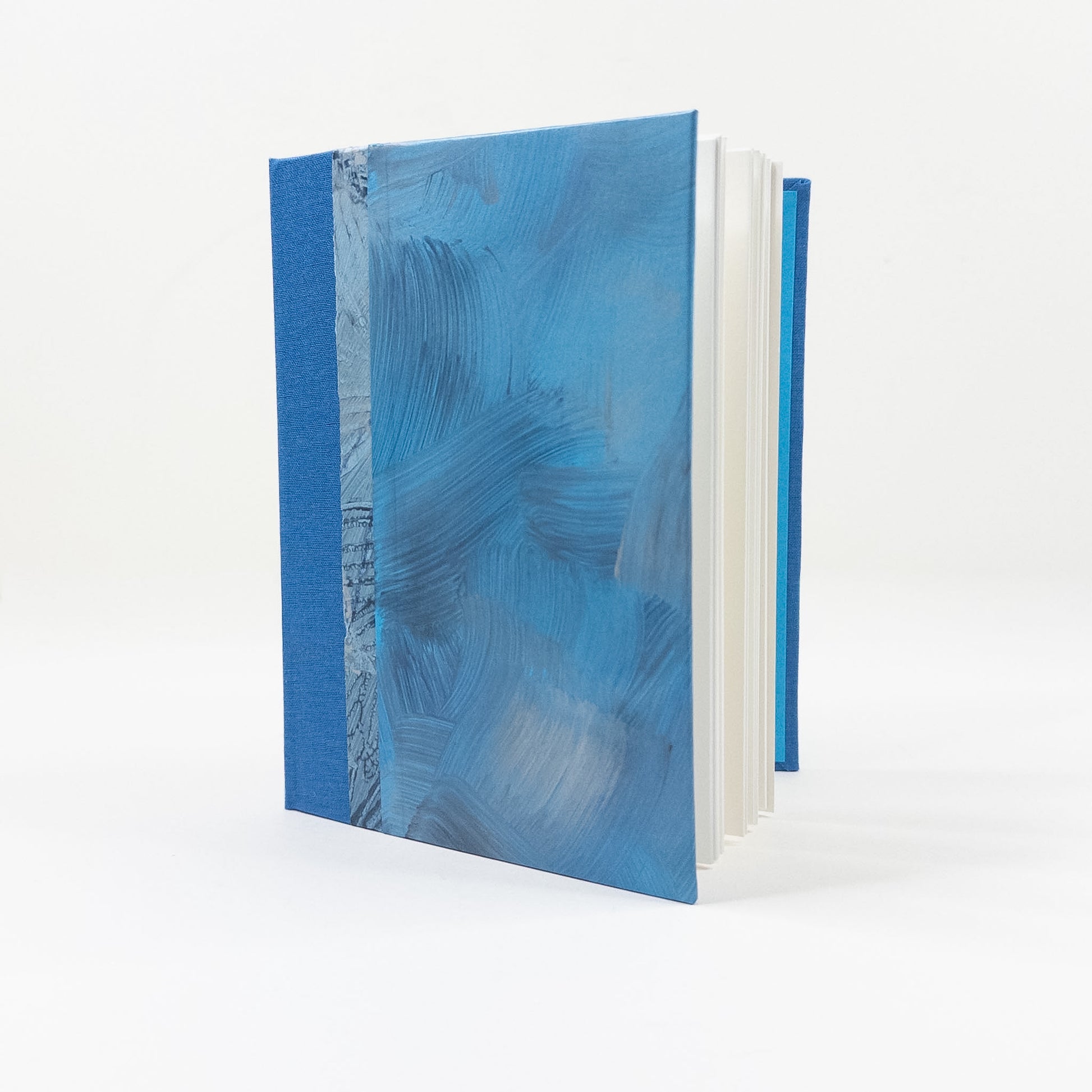Open handmade book showing blank unruled pages and layflat binding