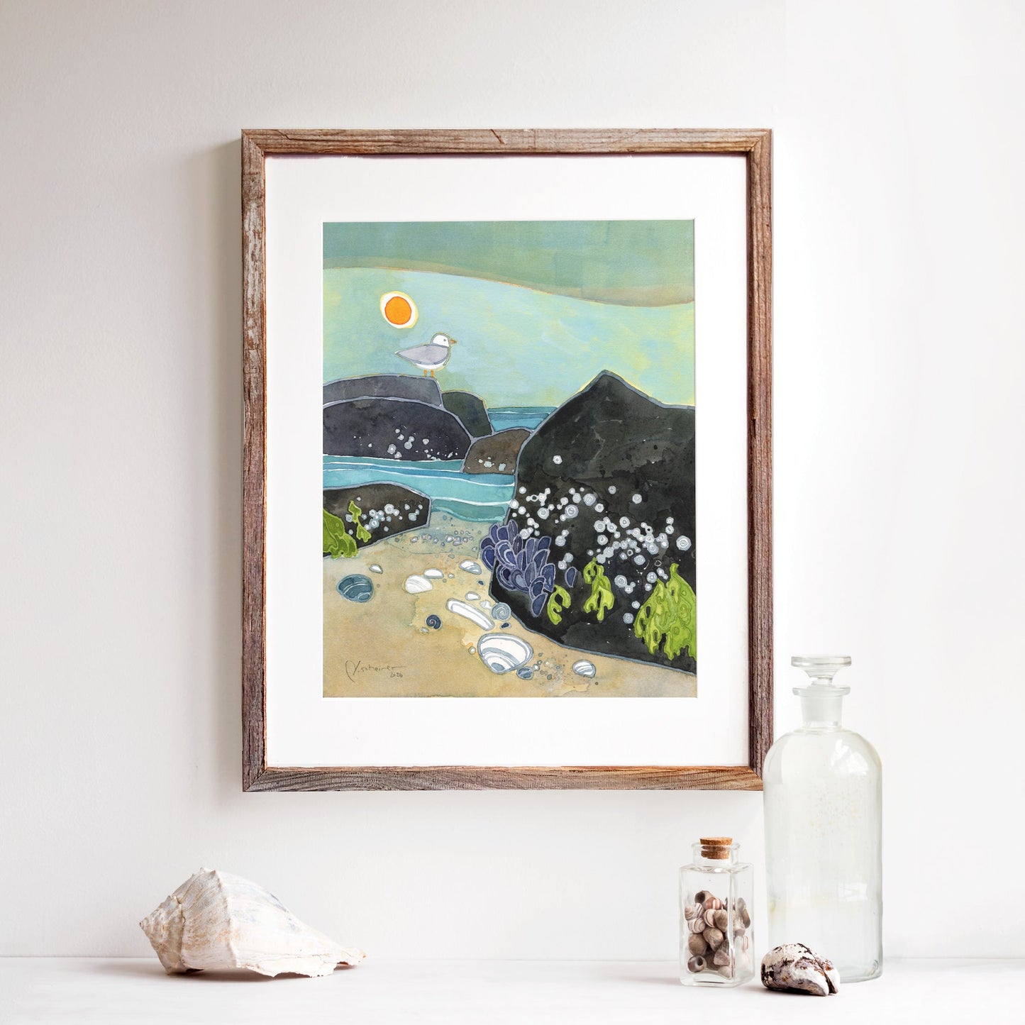 Watercolor print of a rock jetty with barnacles, a gull and clam shells on a hazy beach, matted to 11 by 14 inches